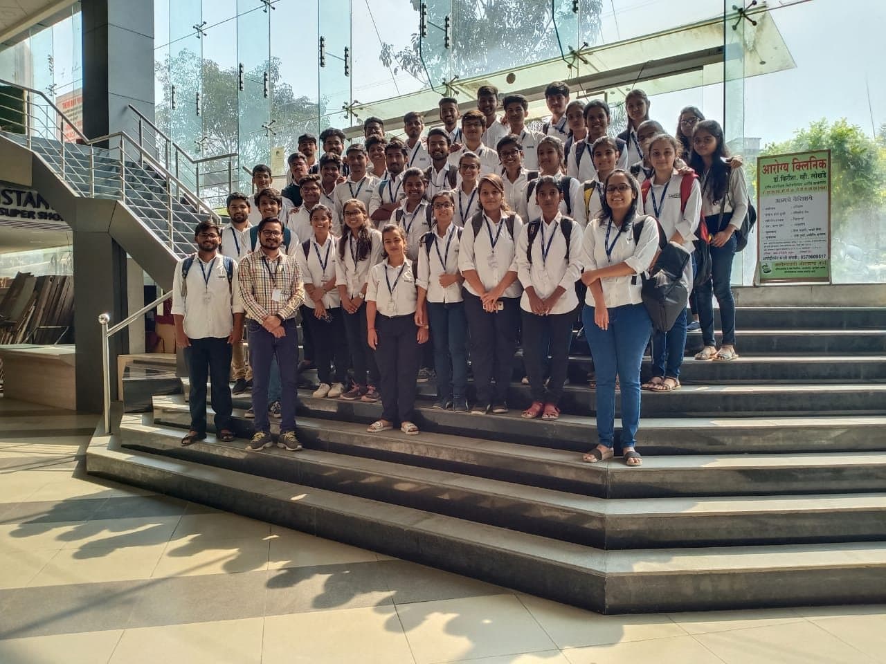 The MMCOE class group on the steps of a glass building during a college visit